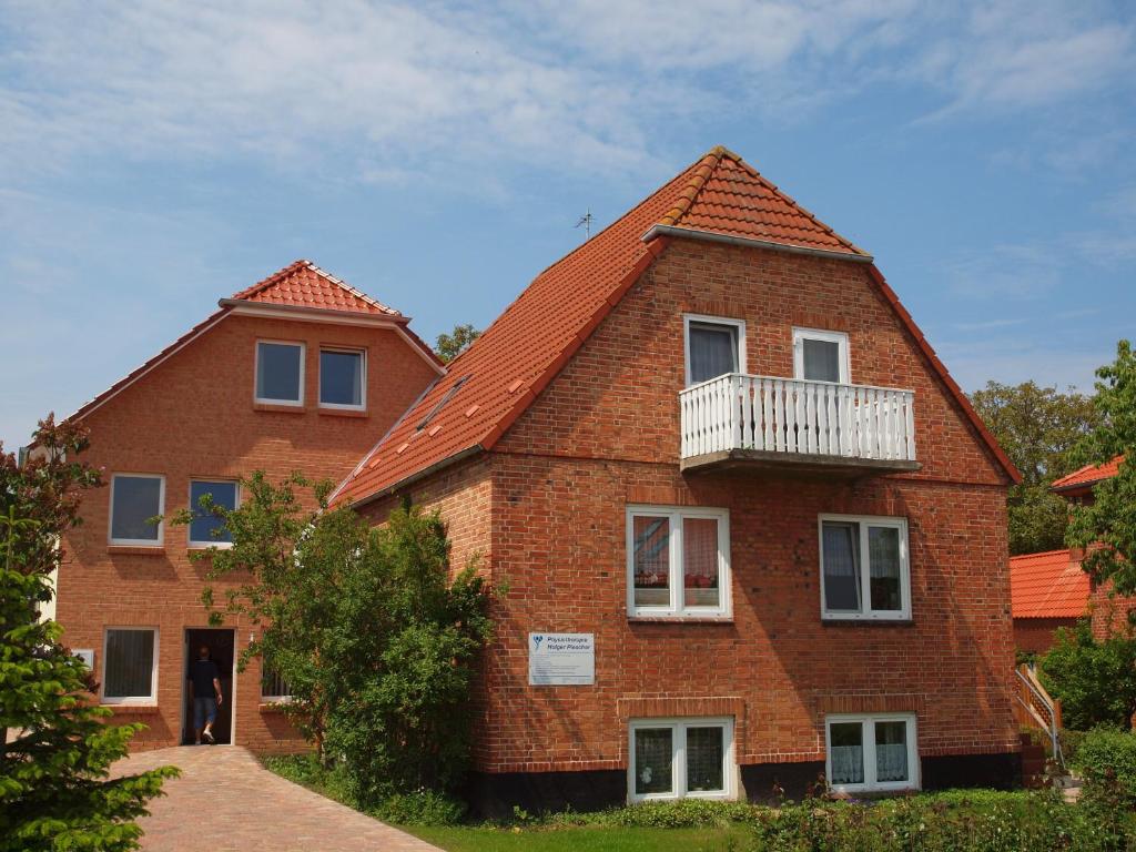 a large red brick house with a balcony at Ferienappartements Holger Plescher in Kühlungsborn