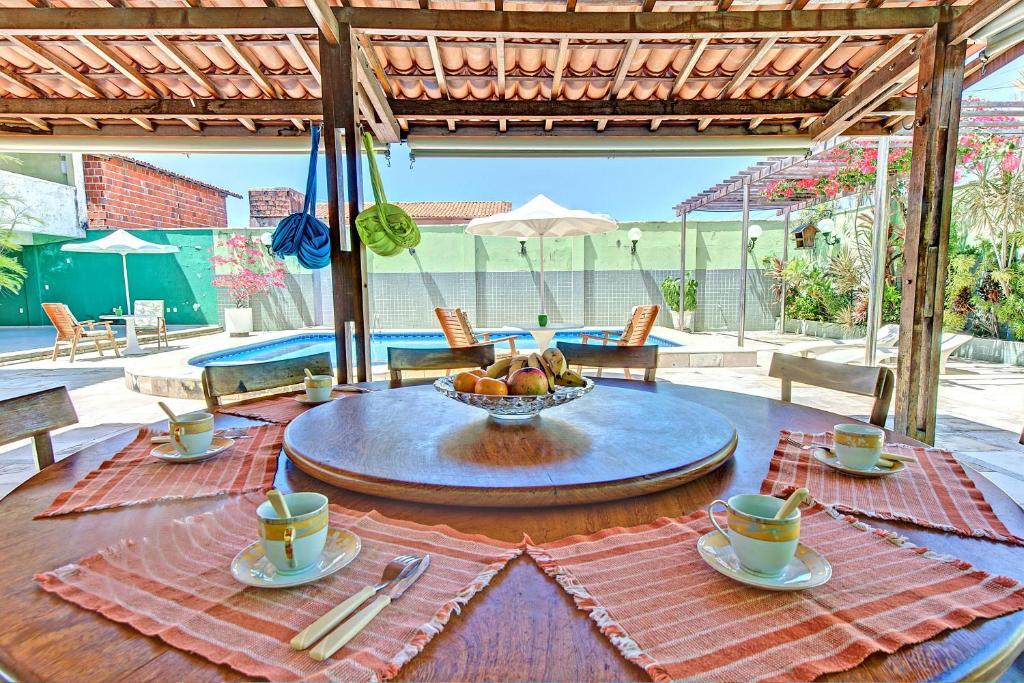 uma mesa com copos e uma tigela de comida em Casa das Andorinhas ao Mar de Iguape por Carpediem em Aquiraz