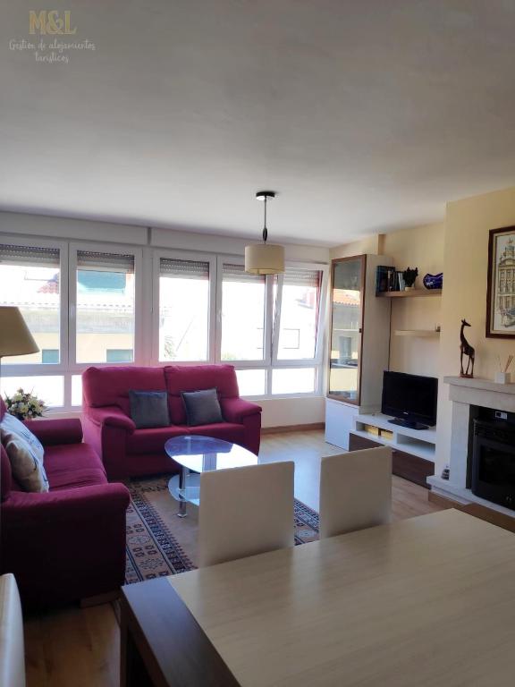 a living room with a red couch and a table at El trocito de mar in Luanco