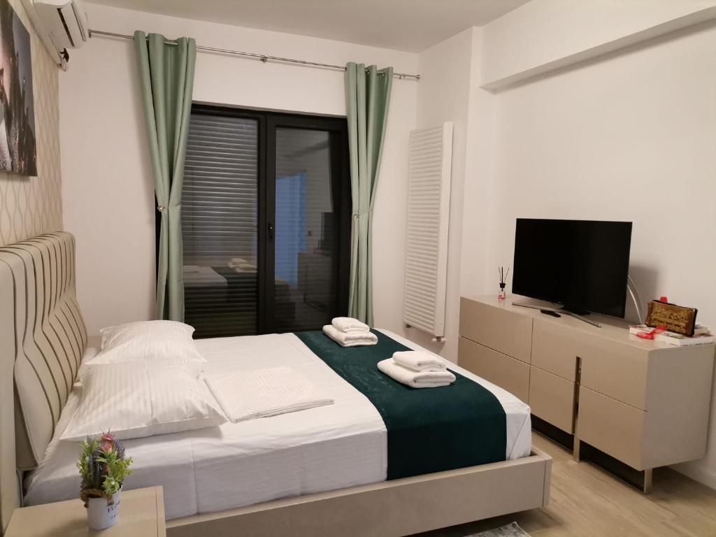 ein Schlafzimmer mit einem Bett, einem Fernseher und einem Fenster in der Unterkunft ZIGON Summer Place by Casa Del Mar in Mamaia