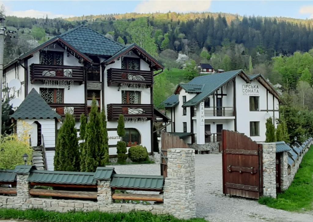 una casa grande con una puerta delante de ella en Girska Sonata Hotel & Apartments, en Mykulychyn