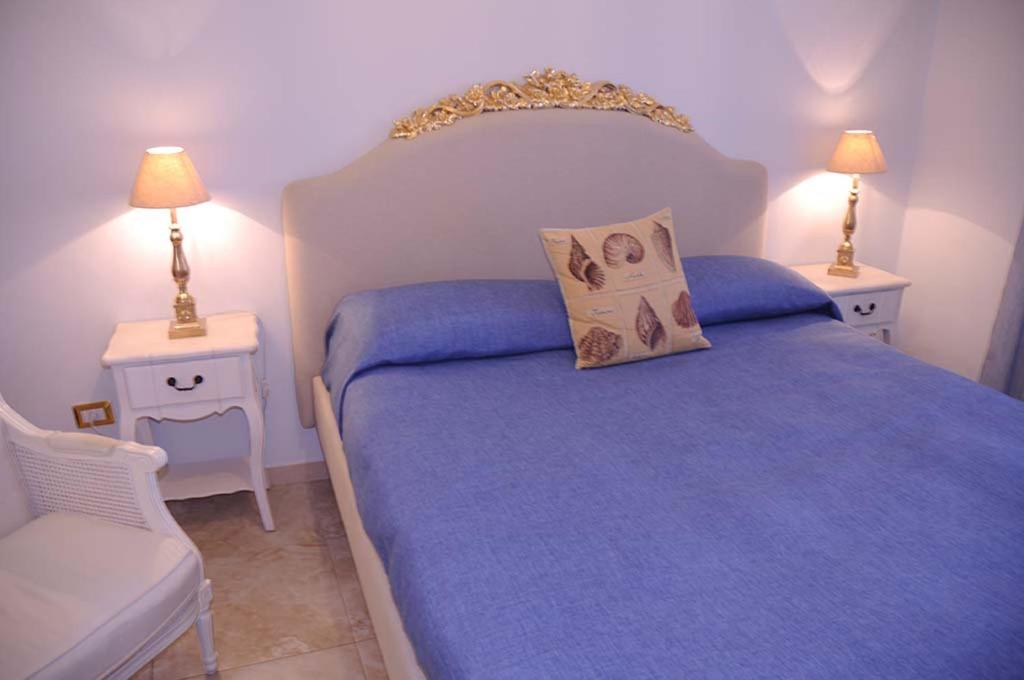 sypialnia z niebieskim łóżkiem i 2 szafkami nocnymi w obiekcie AFFITTACAMERE A TRE MINUTI IN SPIAGGIA Il Veliero w mieście San Vito lo Capo