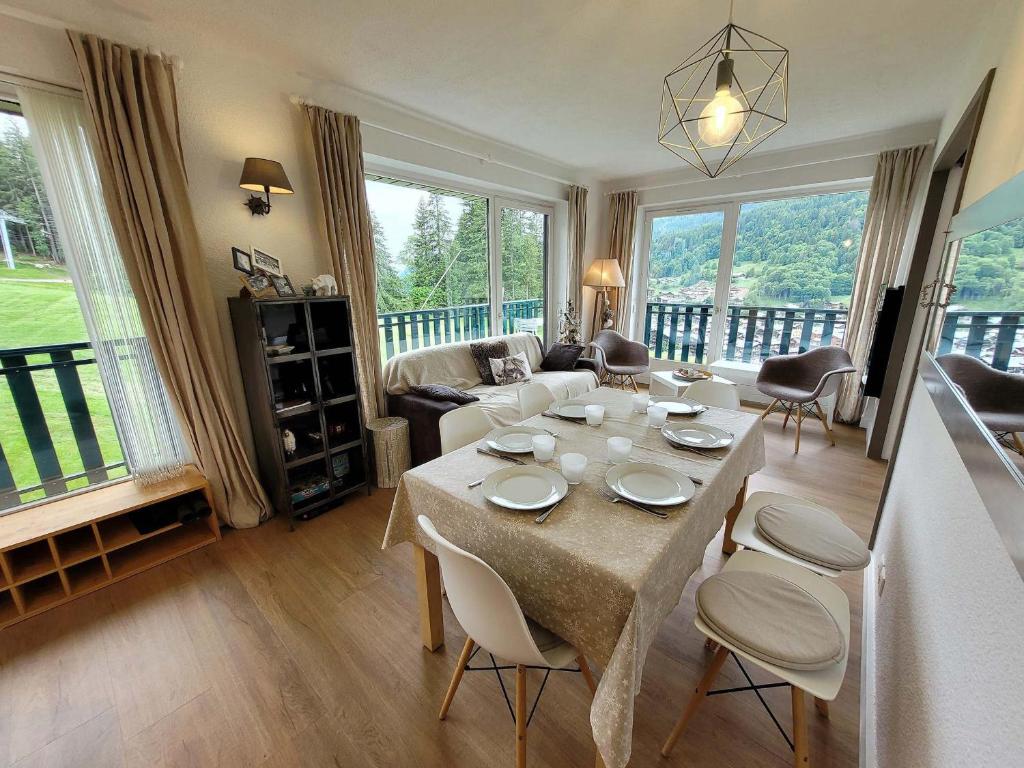 un salon avec une table avec des chaises et un canapé dans l'établissement Appartement skis aux pieds avec piscine, rénové et confortable - FR-1-598-18, aux Gets