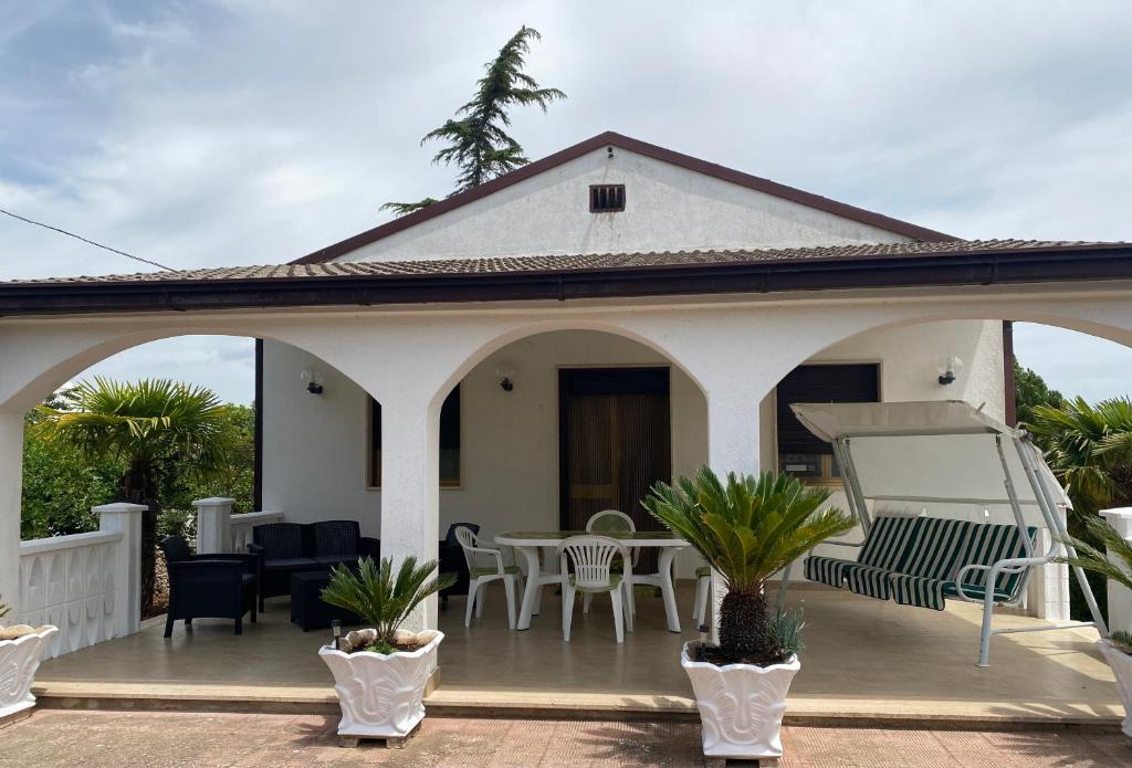 Villa Mima في سانتيرامو إن كولي: بيت أبيض مع فناء مع طاولة وكراسي