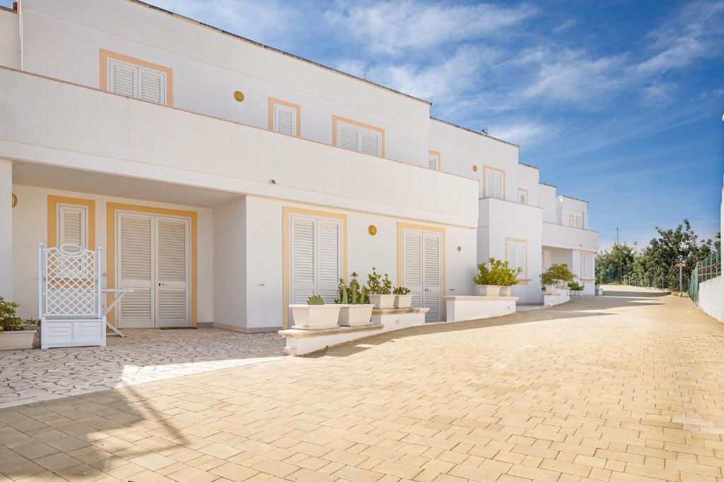 een groot wit gebouw met een patio ervoor bij Residence Bellevue in Leuca