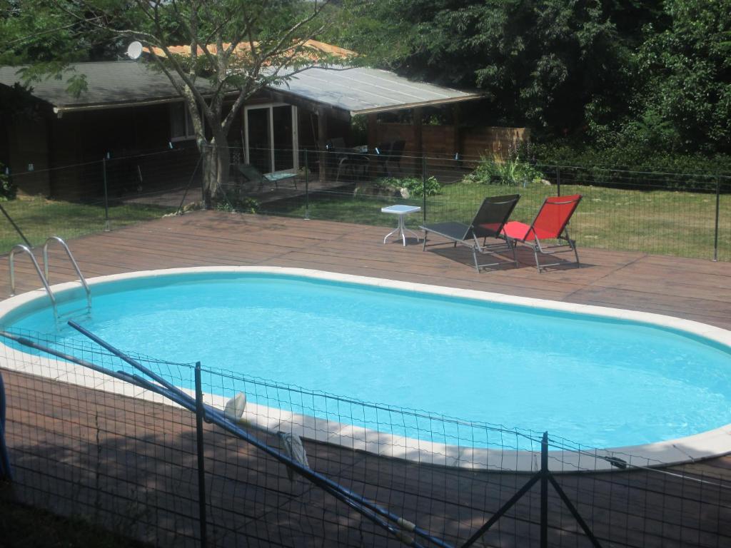 a swimming pool with two chairs and a table at Mas Torrenaps in Argelès-sur-Mer