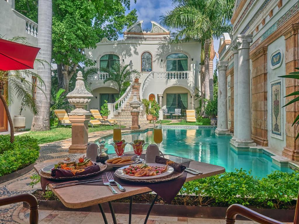 un tavolo con cibo sopra di esso di fronte a una casa di El Palacito Secreto Luxury Boutique Hotel & Spa a Mérida