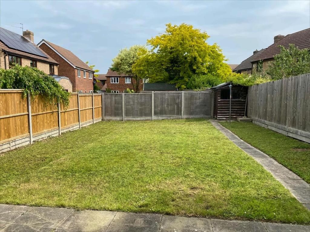 a backyard with a fence and a yard at Exclusive Homely Cambridge 4 bed house with free parking, big garden and sleeps 10 in Cambridge