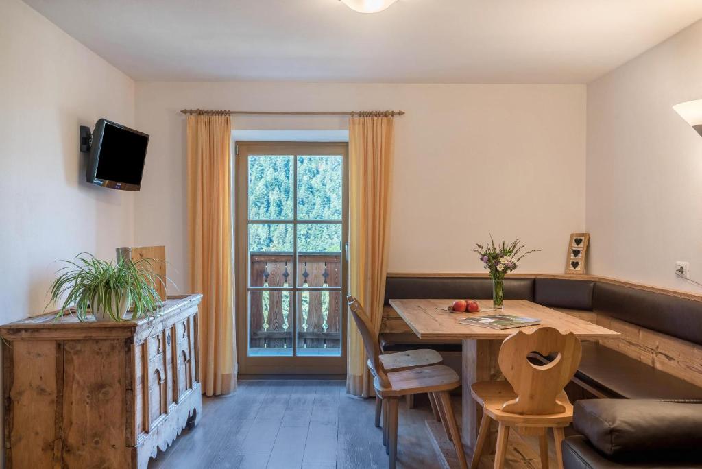 ein Wohnzimmer mit einem Tisch und einem Fenster in der Unterkunft App Sonnenblume Biohof Unterspisser in Lajen