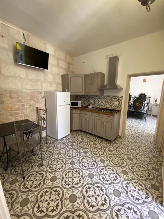 a kitchen with a refrigerator and a table in it at fiori catene tra le torri in Conversano