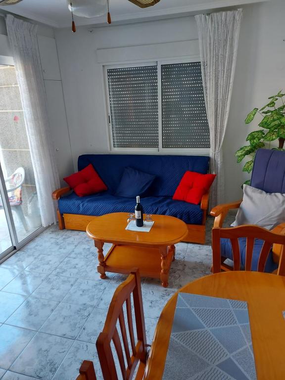 a living room with a blue couch and a table at Fuensanta 400m to Beach Med Syndicate 10 in Torrevieja