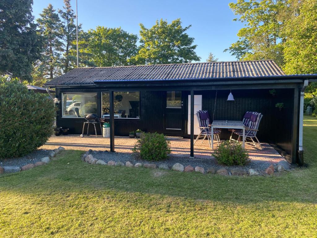 a black cabin with two chairs and a table at Pomonahouse in Nakskov