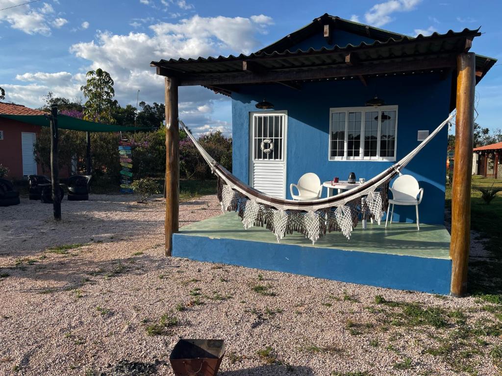 a blue house with two chairs and a hammock at Chalé Uyuni in Alto Paraíso de Goiás