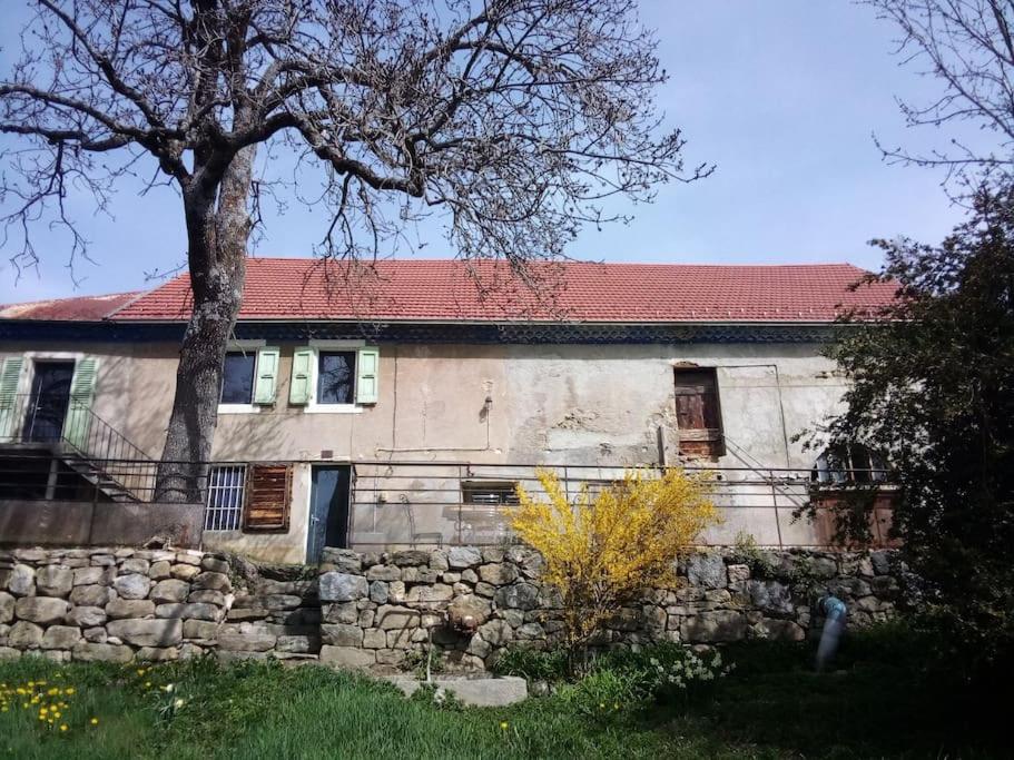 kamienny budynek z czerwonym dachem i drzewem w obiekcie ferme rénovée campagne gap hautes alpes w mieście Gap