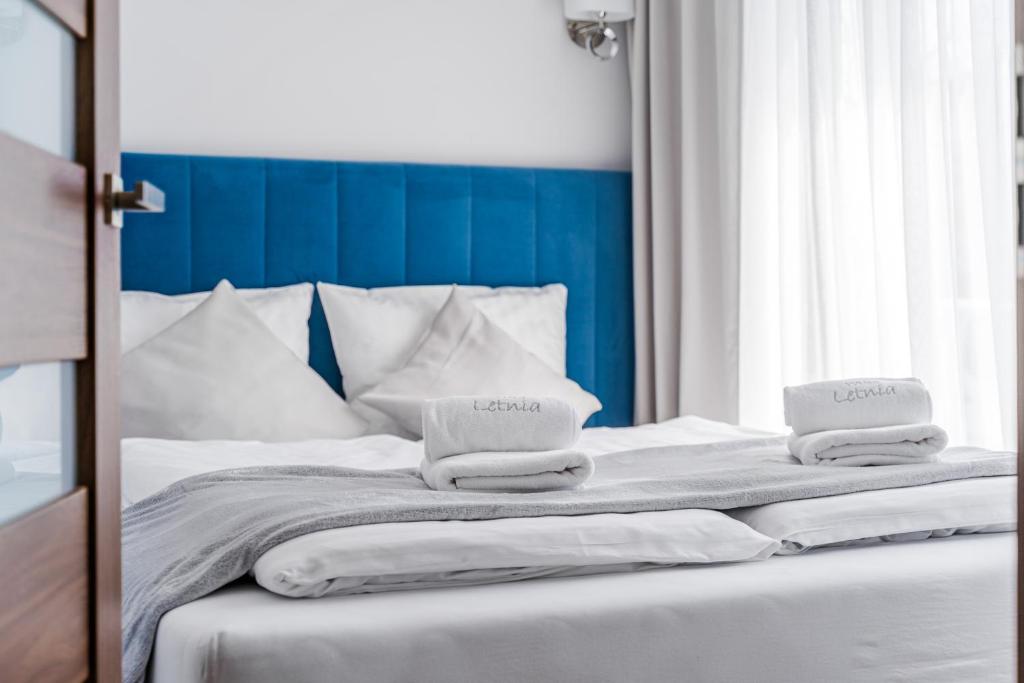 a bed with two folded towels on top of it at Willa Letnia in Krynica Morska