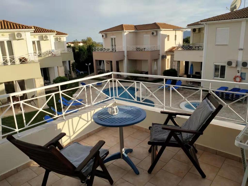 un patio con 2 sillas y una mesa en el balcón en Kalamaki Court Villas Unit9 en Kalamaki