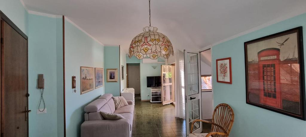 un soggiorno con divano e lampadario pendente di La casina al mare a Marina di Massa