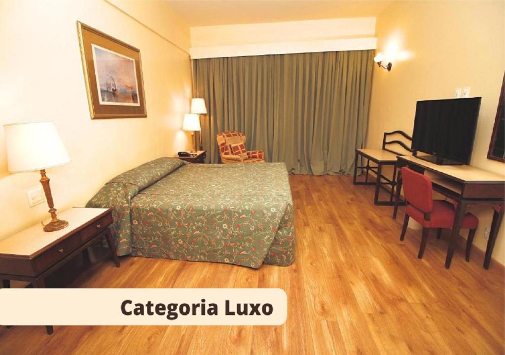 Habitación de hotel con cama y escritorio con ordenador en Dayrell Hotel e Centro De Convenções en Belo Horizonte