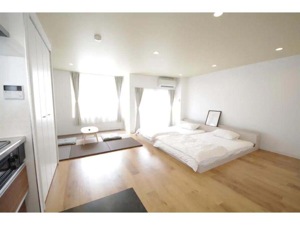 una camera da letto bianca con un letto e due finestre di HOTEL APT SESELA - Vacation STAY 12883 a Kanazawa