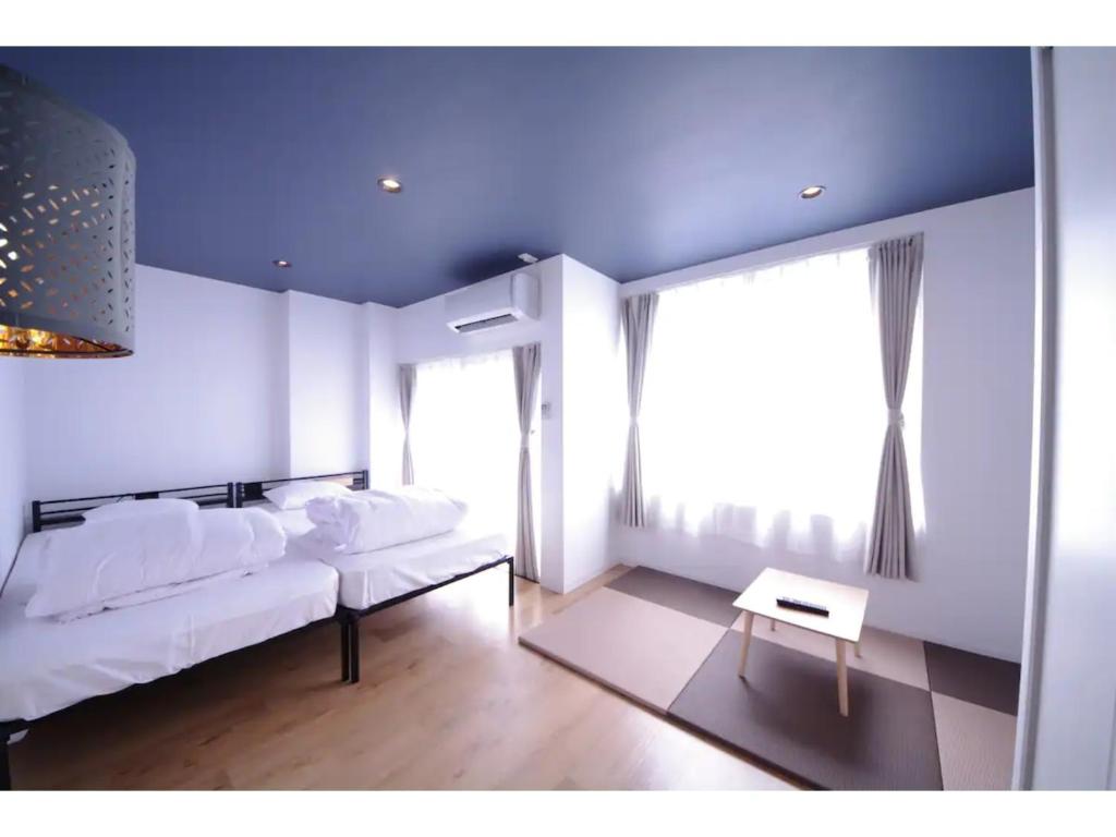 a bedroom with a white bed and a table in it at HOTEL APT SESELA - Vacation STAY 12882 in Kanazawa
