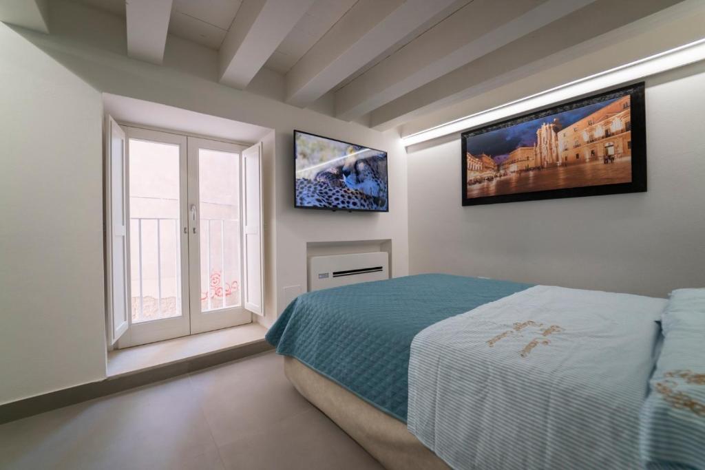 1 dormitorio con cama y ventana en Ortigia Charme piazza Duomo, en Siracusa