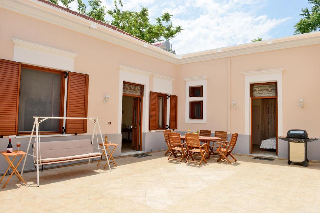 Un patio con mesa y sillas y parrilla. en Classical Villa Archontiko D&amp;M, en Rodas