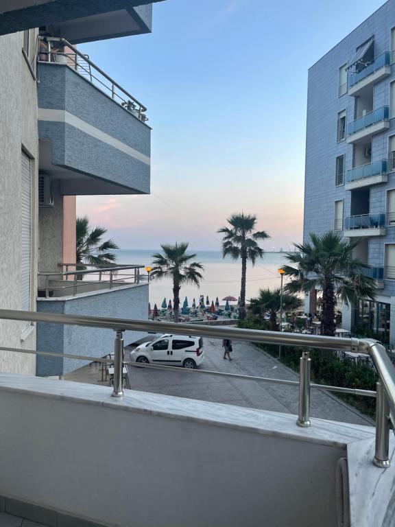 a white car parked on a street with palm trees at Kokomani in Durrës