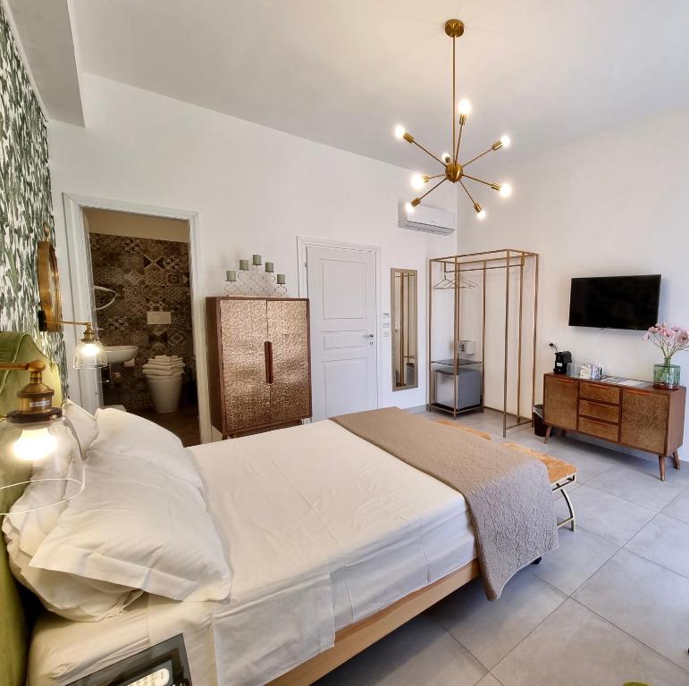 - une chambre avec un grand lit et un lustre dans l'établissement Dimora Giusti, à Lecce