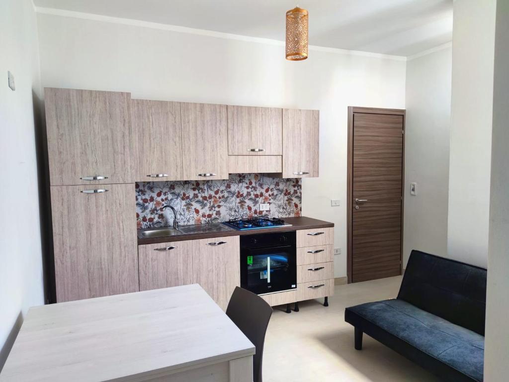 a kitchen with wooden cabinets and a stove top oven at My Home Lampedusa in Lampedusa