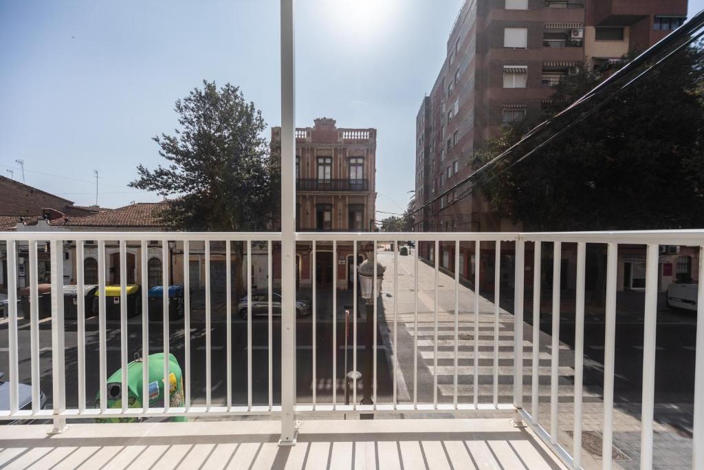 a balcony with a white railing and a street at Reinapart Valencia Beach in Valencia