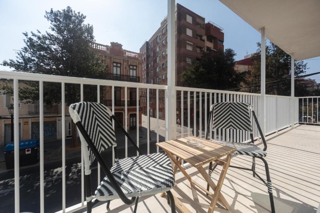 a wooden table and chairs sitting on a balcony at Reinapart Valencia Beach in Valencia