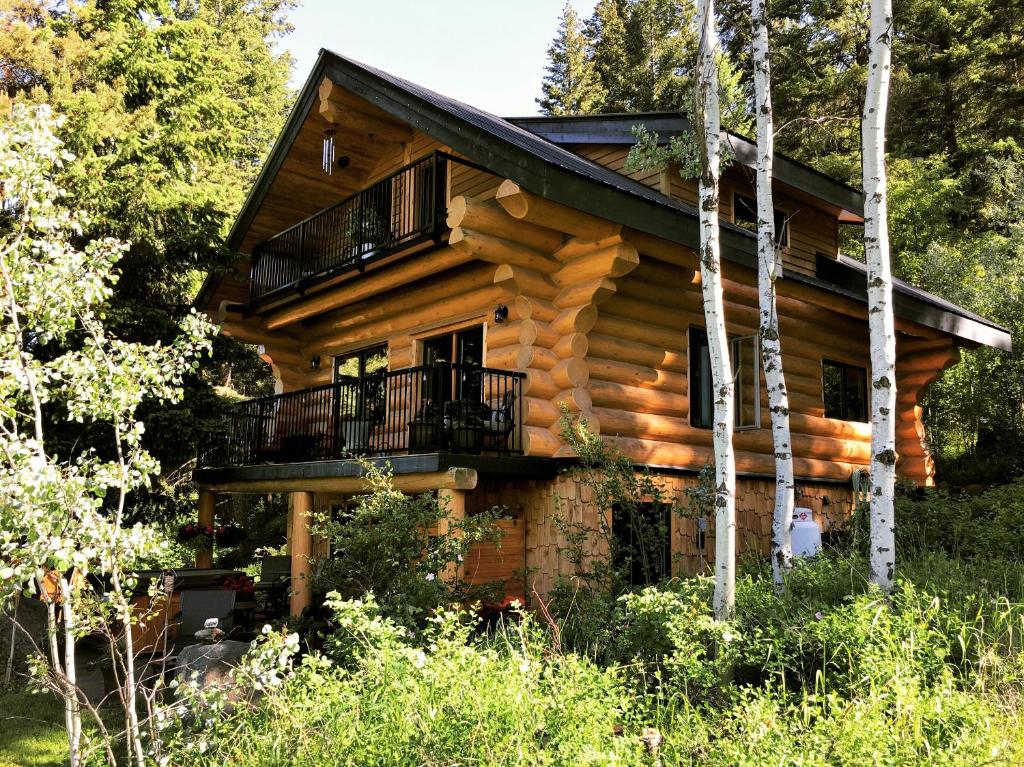 um chalé de madeira na floresta com uma varanda em A Suite Retreat - Beyond Bed & Breakfast em Sun Peaks