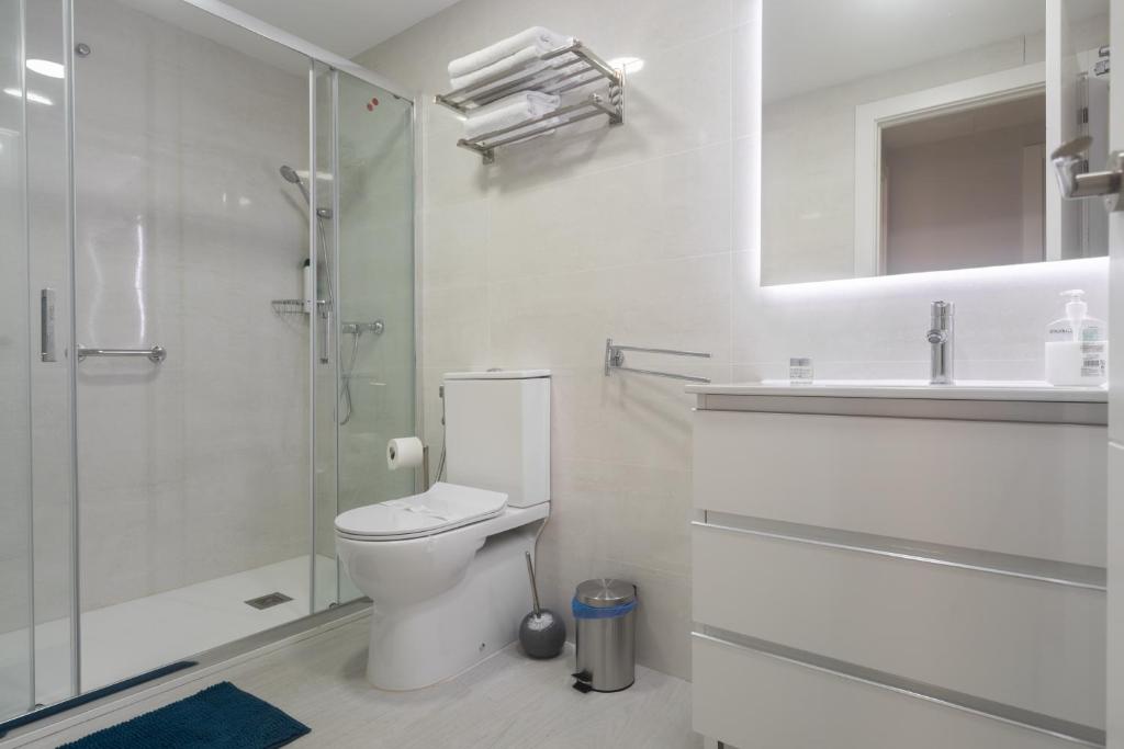 a white bathroom with a toilet and a shower at Reinapart Valencia Beach in Valencia
