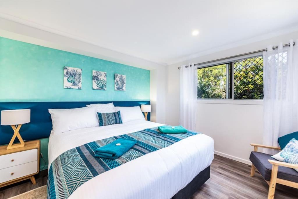 a blue and white bedroom with a bed and a window at Central Location - Noosa Address - Pet Friendly in Noosa Heads