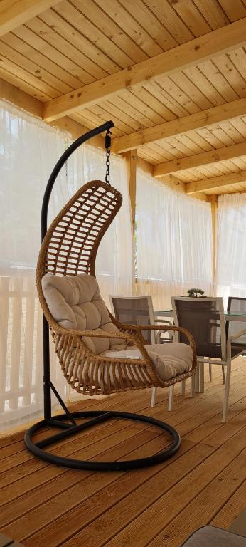 uma cadeira de vime pendurada num quarto com uma mesa em TAKE IT EASY Mobile Home, Camp Basko Polje #New2022 em Baška Voda