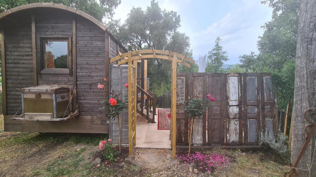 una pequeña casa con una puerta abierta y una puerta en La roulotte, en Carbuccia