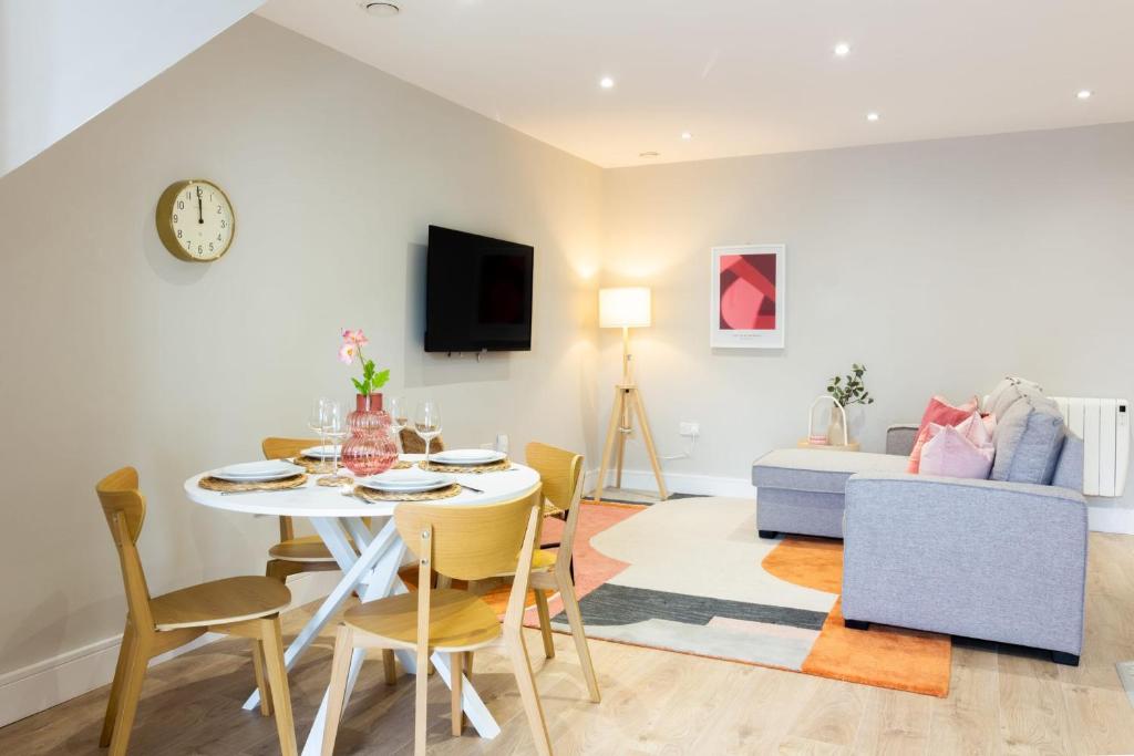 sala de estar con mesa, sillas y sofá en Guestready - Encantando 1BR Flat no Newmarket Hall en Dublín