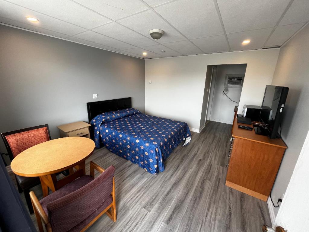 康沃爾的住宿－伊萊科特旅5號旅館，配有床、桌子和电视的房间