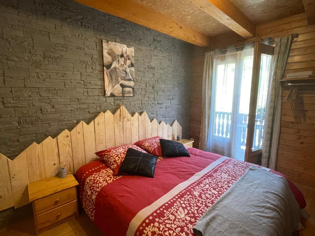 - une chambre avec un grand lit et une tête de lit en bois dans l'établissement Le Chalet, chambres d hôtes, petit déjeuner inclus, à Roubion