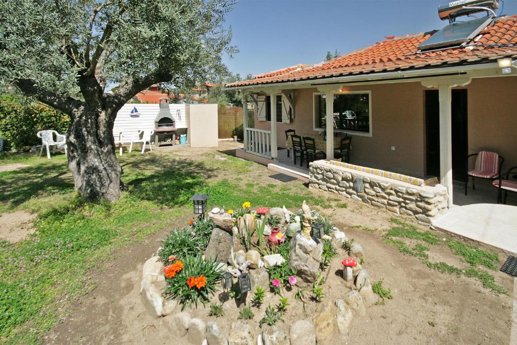 a garden in front of a house with flowers at Efi's Home in Vourvourou