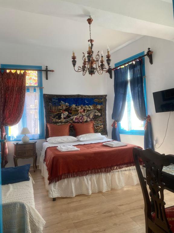 um quarto com uma cama com lençóis vermelhos e cortinas azuis em DIONI em Chania Town