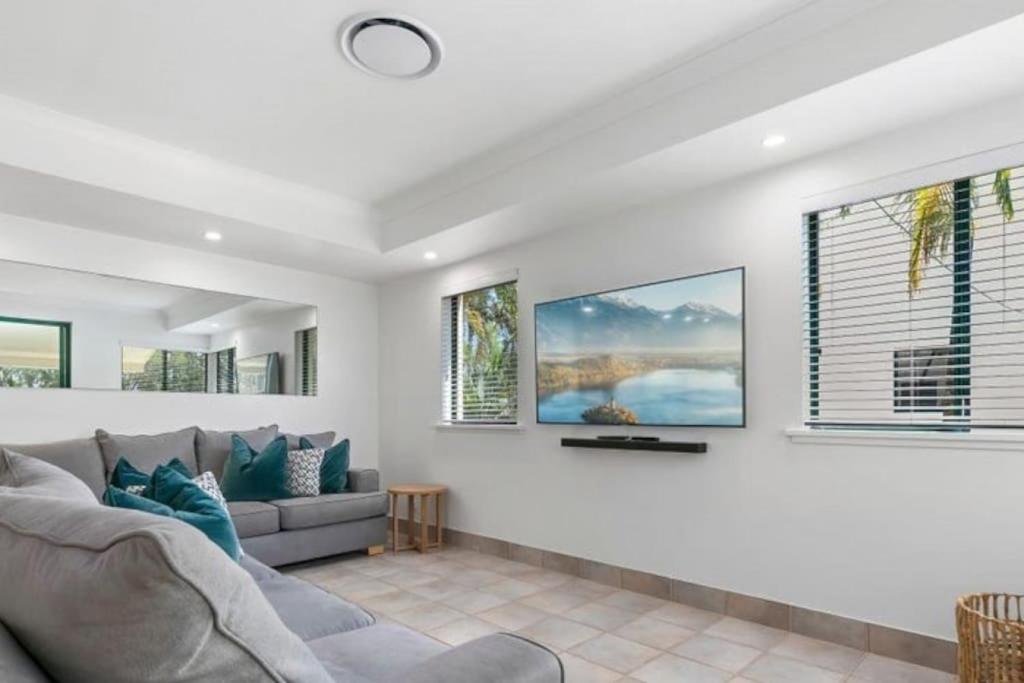 a living room with a couch and windows at HOWARD 11-7 Noosa River at your doorstep in Noosaville