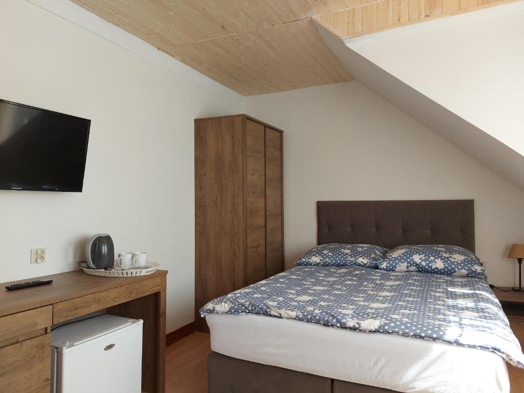 ウェバにあるWidok Na Portのベッドルーム1室(ベッド1台付)、テレビが備わる屋根裏部屋