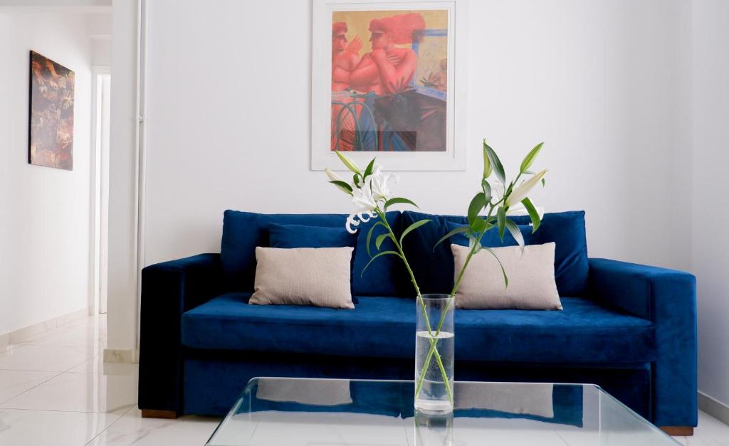 un divano blu in soggiorno con tavolo in vetro di IOFONTOS 14 ad Atene