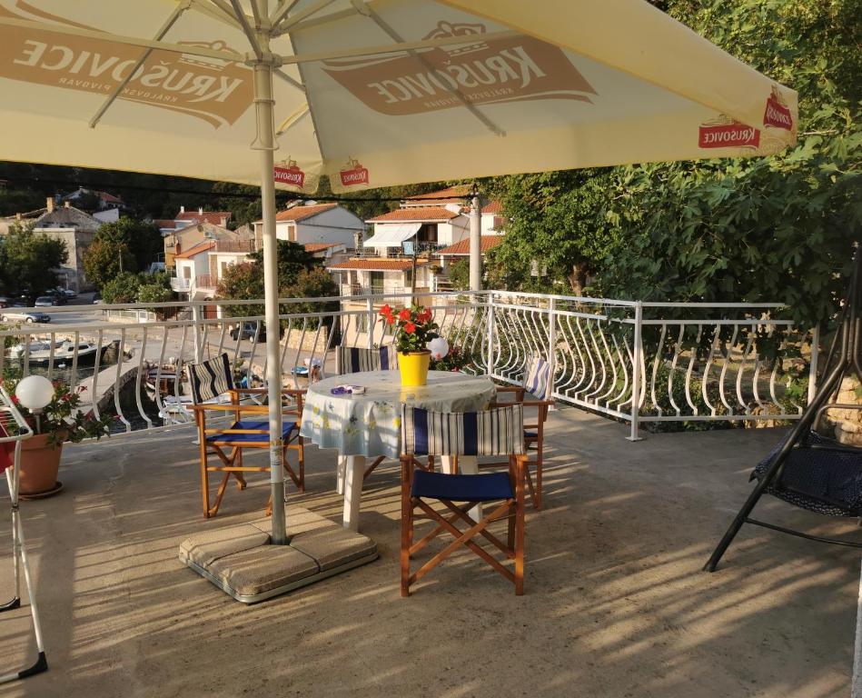 a table and chairs under an umbrella on a patio at Apartments Jakov in Starigrad