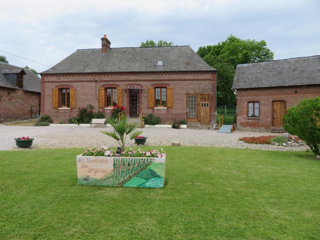 a large brick house with a plant in the yard at LA FERMETTE DE L'YERES in Aubermesnil