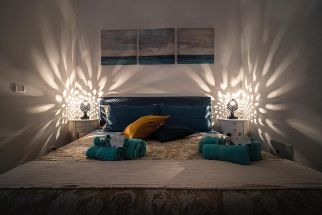 um quarto com uma cama grande com duas luzes em La Casetta del Ronco1 Ortigia em Siracusa