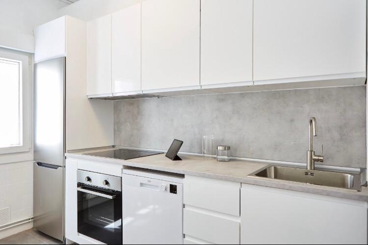 a kitchen with white cabinets and a sink at Apartamento Pamplona in Pamplona
