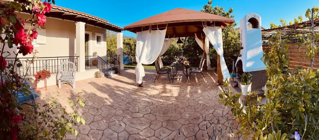 un patio con gazebo, tavolo e sedie di Villa Doreta a Roda