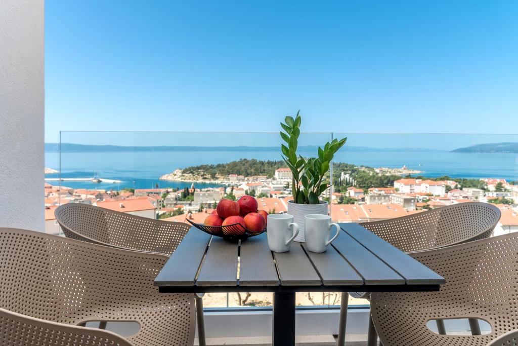 einen Tisch mit einer Obstschale auf dem Balkon in der Unterkunft Luxury Adria SEA & CITY View apartment in Makarska